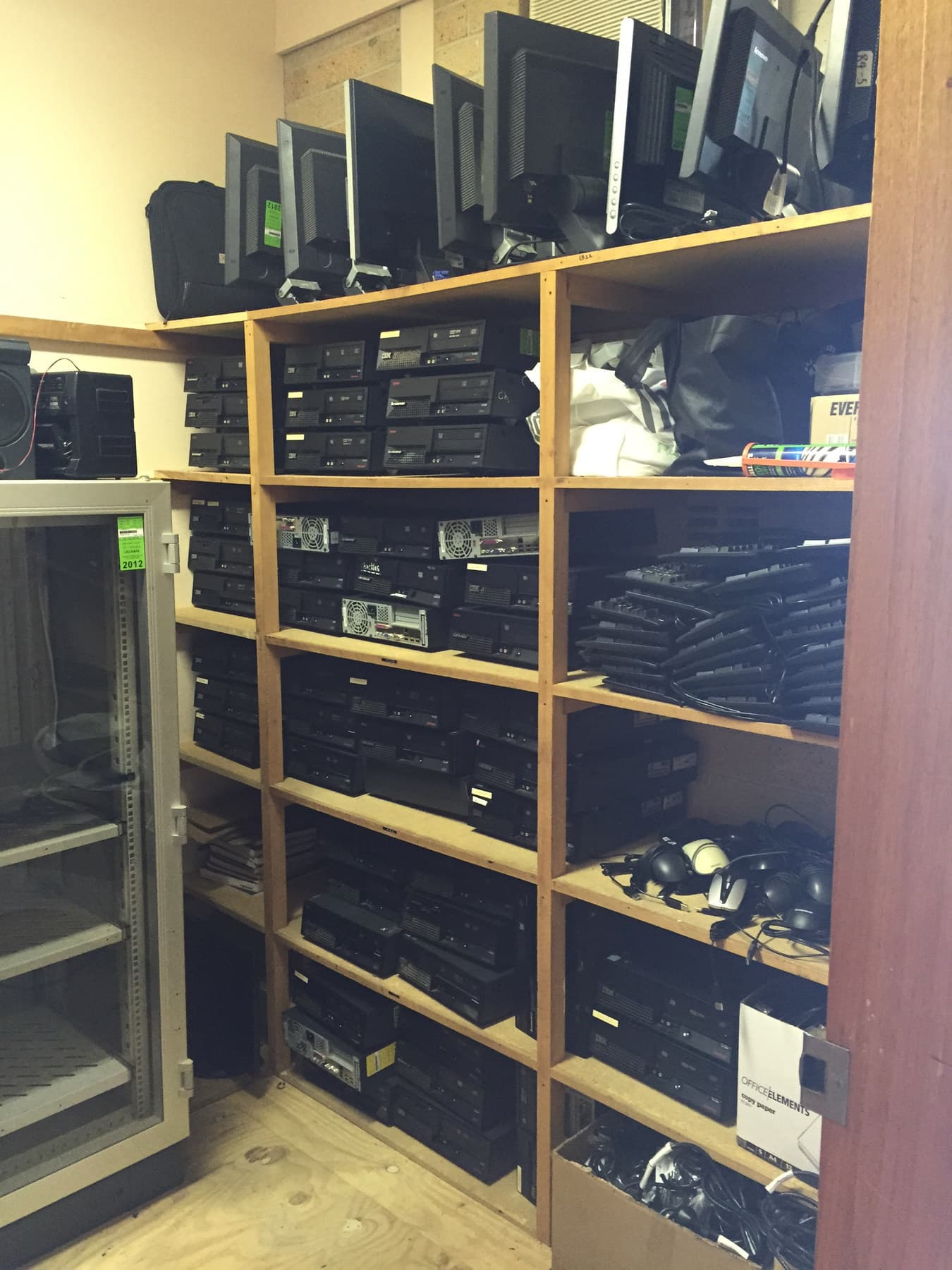 Shelves of reclaimed computers and monitors prepared for reuse